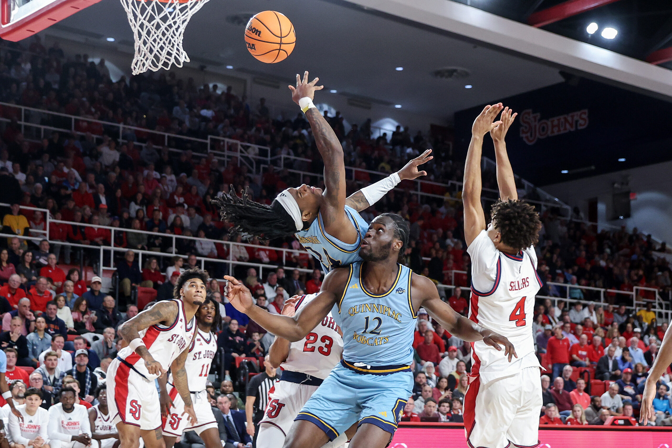Nov 3, 2025; Queens, New York, USA;  Quinnipiac Bobcats guard Jaden Zimmerman (24) collides with forward Spence Wewe (12) in the first half against the St. John's Red Storm at Carnesecca Arena. Mandatory Credit: Wendell Cruz-Imagn Images